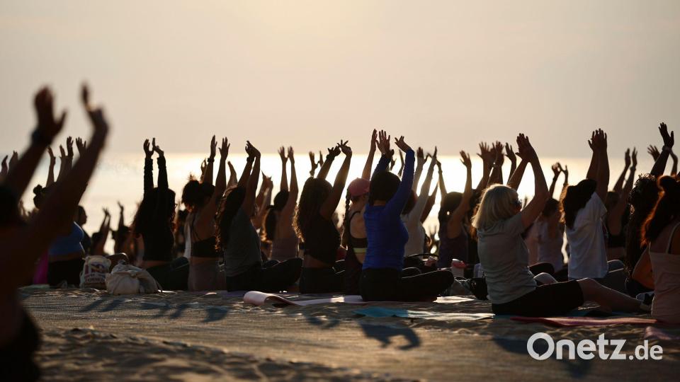 Hunderte Menschen nehmen an einer öffentlichen Yoga-Stunde am frühen Morgen am „Oak Street Beach“ am Lake Michigan teil. Bild: Christian Charisius/dpa