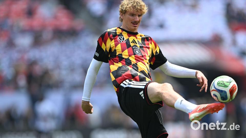 Die DFB-Spieler um Nick Woltemade wärmten sich in auffälligen Shirts auf. Bild: Federico Gambarini/dpa