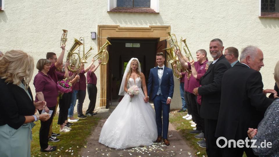 Nicolas und Michelle Braun haben geheiratet. Mit erhobenen Instrumenten Spalier stand der Posaunenchor, für den Dirigentin Katrin Seidl (links) mit einem Geschenk und Blumenstrauß gratulierte.. Bild: Siegfried Bock