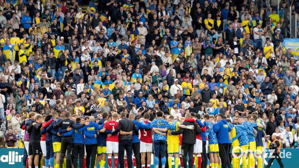 Nach dem Zusammenbruch von Christian Eriksen versammeln sich dänische und ukrainische Spieler gemeinsam auf dem Spielfeld. Bild: Bo Amstrup/Ritzau Scanpix Foto/AP/dpa