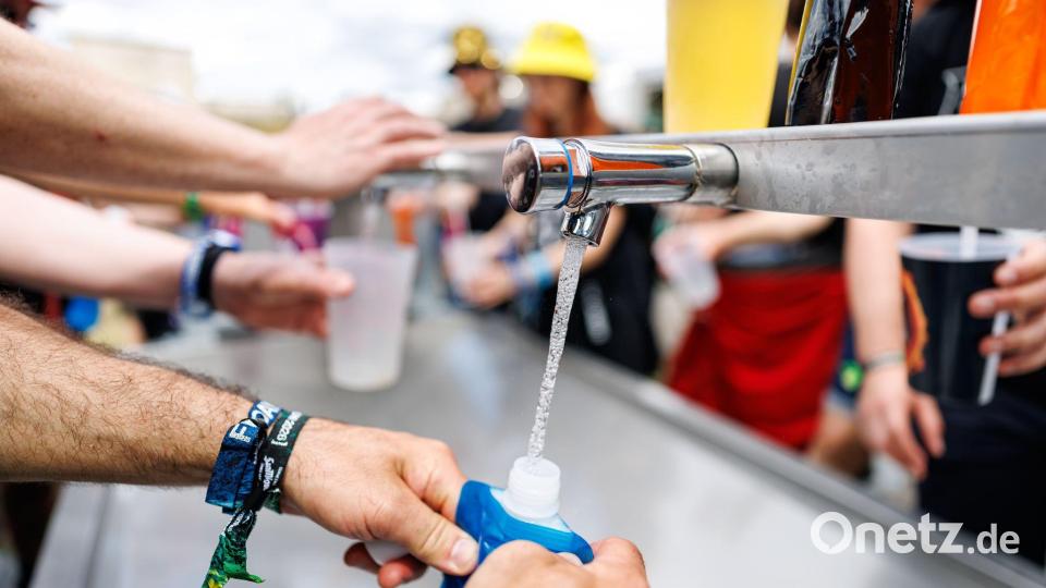 Auch an den Wasserstellen bildeten sich zeitweise Schlangen. Bild: Daniel Karmann/dpa