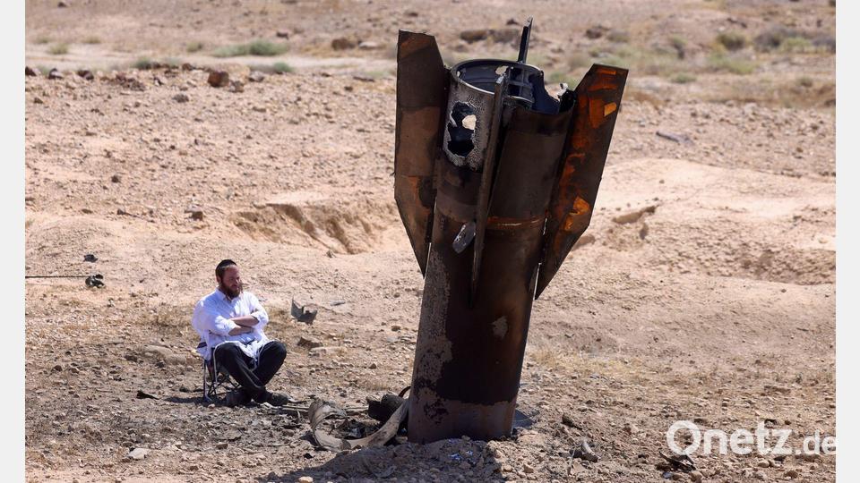Ein Mann betrachtet das Wrack einer Rakete, die nach einem iranischen Angriff im Westjordanland aus dem Boden ragt. Bild: Jamal Awad/dpa