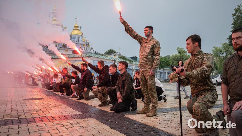 Menschen zünden Fackeln während der Beerdigungszeremonie für einen gefallenen ukrainischen Soldaten in Kiew. Bild: Danylo Antoniuk/AP/dpa