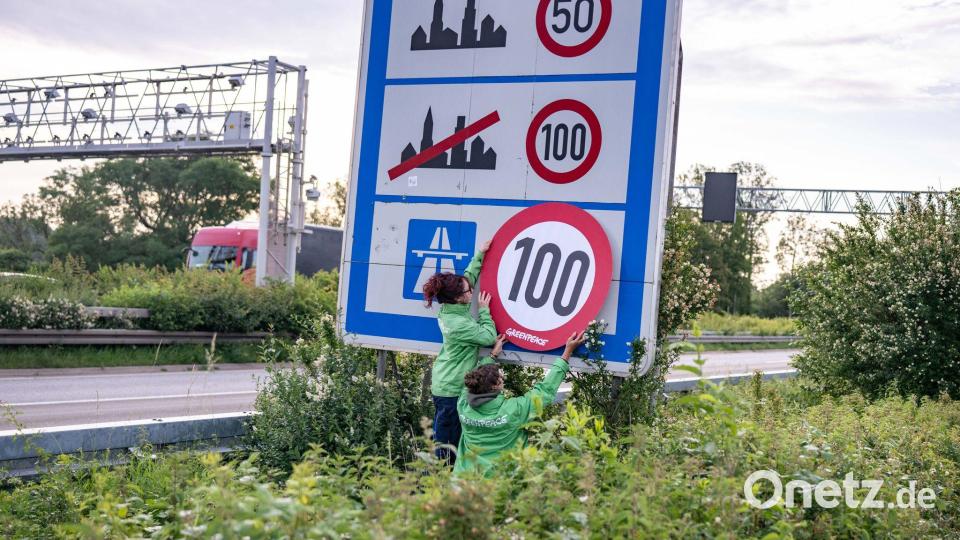 Auf Autobahnen gilt ... ein Tempo-100-Tempolimit? So zumindest wollen es Greenpeace-Aktivistinnen, hier bei der Aktion am Montagmorgen in Aachen. Bild: Benjamin Westhoff/dpa