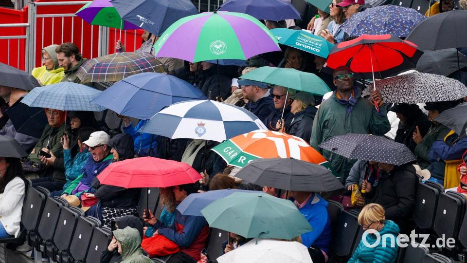 Tennis im Regen: Bei der WTA-Tour in London schützen sich Zuschauer mit Schirmen gegen einen Schauer. Bild: Alberto Pezzali/AP/dpa