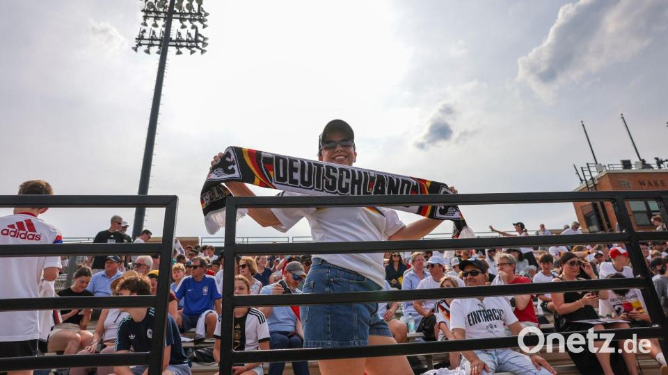 Eine Frau kommt mit Deutschlandschal zur ersten Trainingseinheit der Nationalmannschaft auf das Gelände der Wake Forest University in Winston-Salem. Bild: Jan Woitas/dpa