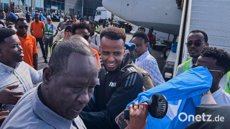 Schiedsrichter Omar Artan (M) wird in der Heimat mit Jubel empfangen. Bild: Farah Abdi Warsameh/AP/dpa