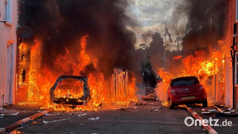 Fahrzeuge brennen in der Lendrick Street in Belfast während Unruhen nach einem Messerangriff am Montagabend. Bild: Pa/PA Wire/dpa