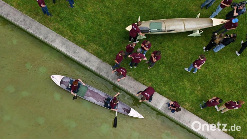 Studenten und Studentinnen der Bauhaus-Universität Weimar fahren mit dem Betonkanu auf dem Wasser im Weimarer Schwanseebad. (Aufnahme mit einer Drohne) Bild: Martin Schutt/dpa