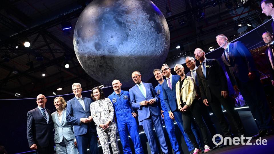 Bundeskanzler Friedrich Merz (6.v.l, CDU) steht unter anderem mit den beiden Esa-Astronauten Alexander Gerst (5.v.l) und Matthias Maurer (7.v.l) während eines Rundgangs auf der Internationalen Luft- und Raumfahrtausstellung (ILA). Bild: Sebastian Gollnow/dpa