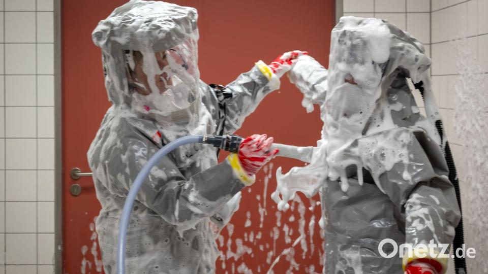 Louise Götze (l) und Ursula Pfitzner, Intensivpflegerinnen und Koordinatorinnen auf der Sonderisolierstation der Charité, desinfizieren sich während eines Pressetermins nach der Rückkehr aus dem Patientenzimmer in der Schleuse mit einer Schaumlösung. Bild: Soeren Stache/dpa