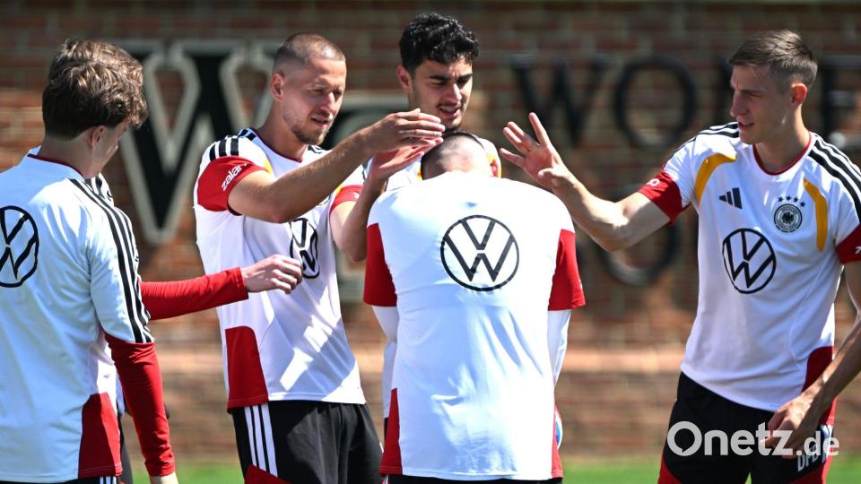 Deniz Undav (M) bekommt beim Kreisspiel von den Kollegen die Ohren geschnippst. Bild: Federico Gambarini/dpa
