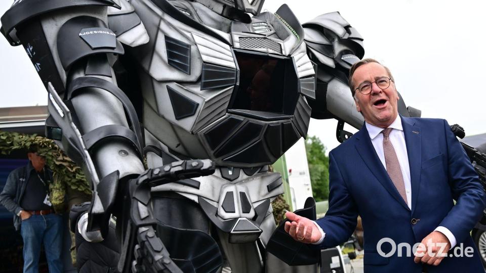 Verteidigungsminister Pistorius scherzt neben einer Transformer-Figur bei der ILA 2026 in Berlin. Bild: Sebastian Gollnow/dpa