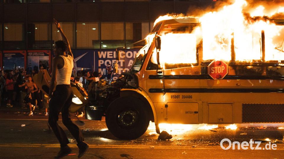 Ein Bus wird in Brand gesteckt. Bild: Derek French/ZUMA Press Wire/dpa
