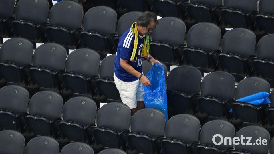 Ein japanischer Fan räumt den Müll weg beim WM-Spiel im Dallas-Stadion. Bild: Jessica Tobias/AP/dpa