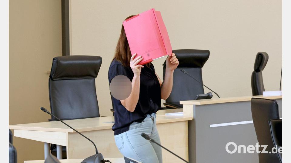 Die Angeklagte betritt den Gerichtssaal mit rotem Aktendeckel vor dem Gesicht. Bild: A7120 Bernd Wüstneck/dpa