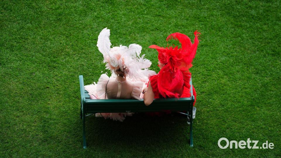 Rennbesucherinnen sitzen auf einer Bank am ersten Tag des Royal Ascot auf der Pferderennbahn von Ascot. Bild: David Davies/PA Wire/dpa