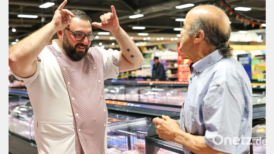 Metzger Yevgeniy Klibanov zeigt die Gebärde für „Rind“. Bild: Daniel Löb/dpa