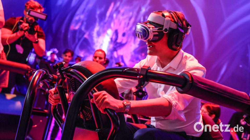 Ein wilder Ritt bei der Gamescom 2024: Hendrik Wüst auf einem „Drachen“, genauer gesagt mit virtueller Brille auf einem schwankenden Gestell. Bild: Oliver Berg/dpa