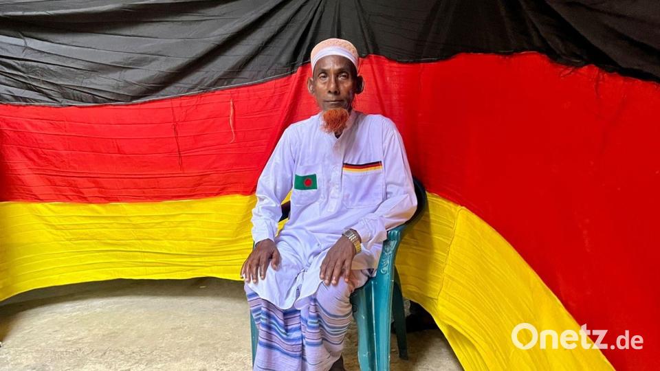 Der 77-jährige bangladeschische Bauer Amjad Hossain posiert mit einer deutschen Fahne, die er zu Hause genäht hat. Bild: Nazrul Islam/dpa