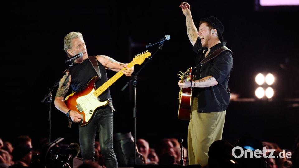 Maffay (l-r) und Oerding spielen gemeinsam auf der Bühne im Hamburger Volksparkstadion. Bild: Gregor Fischer/dpa