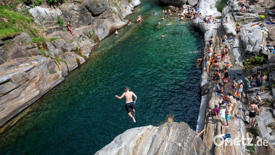 Menschen suchen Abkühlung im Wasser des Flusses Verzasca in der Schweiz. Bild: Samuel Golay/KEYSTONE/dpa