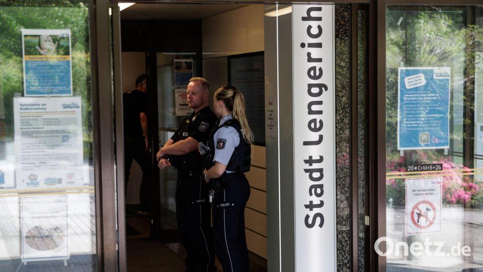 Einsatzkräfte stehen am Eingang des Rathauses. Bild: David Ebener/dpa