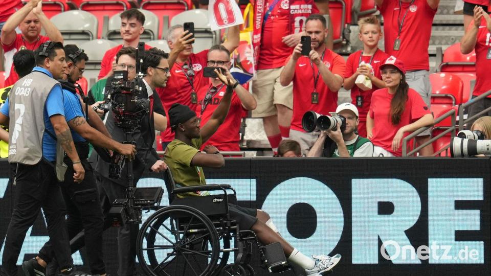 Im Rollstuhl: Koné wird im Stadion begrüßt. Bild: Abbie Parr/AP/dpa