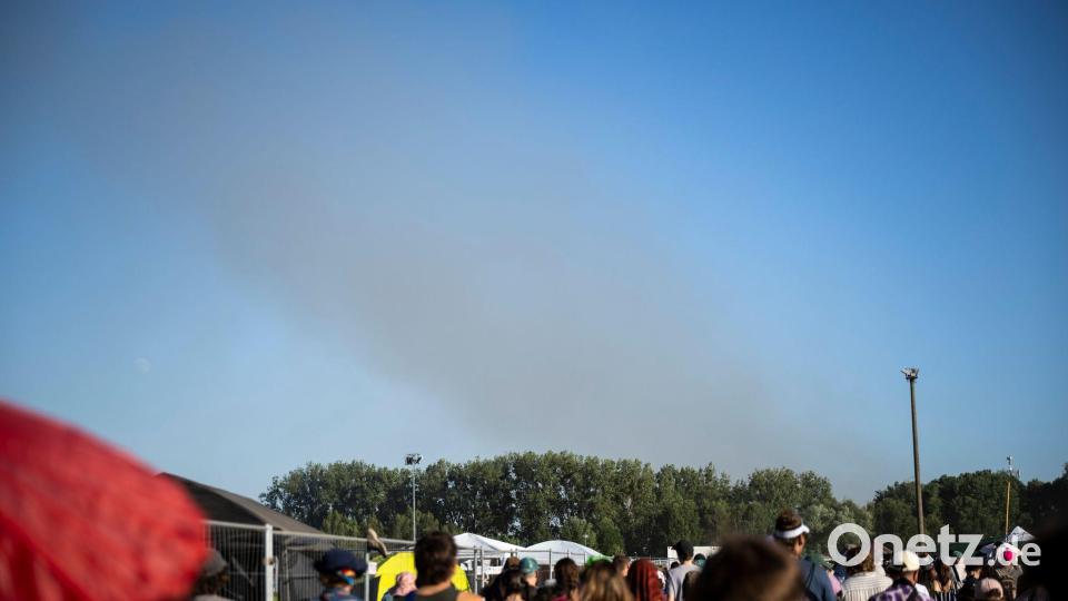 Eine Rauchsäule steigt unweit des Festivalgeländes in die Luft. Bild: Philip Dulian/dpa