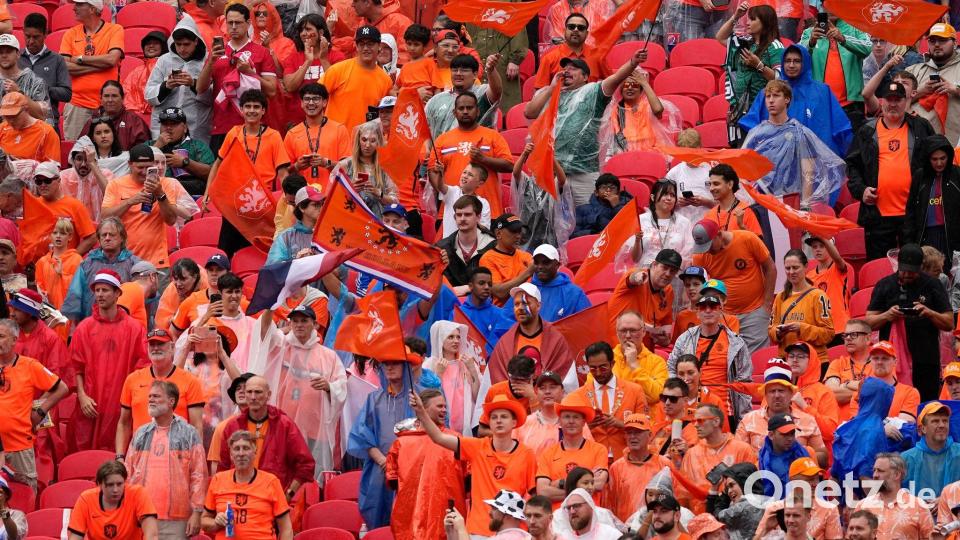 Die Oranje-Fans ließen sich die gute Stimmung vom schlechten Wetter nicht vermiesen. Bild: Charlie Riedel/AP/dpa