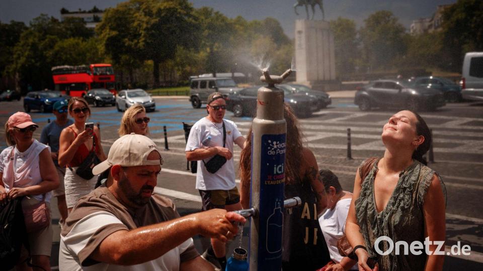 Während einer Hitzewelle in Paris suchen Menschen an einem Nebelbrunnen auf der Place du Trocadéro Abkühlung. Bild: Dimitar Dilkoff/AFP/dpa