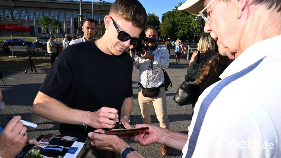 Ferdinand Hofer schreibt Autogramme. Bild: Felix Hörhager/dpa