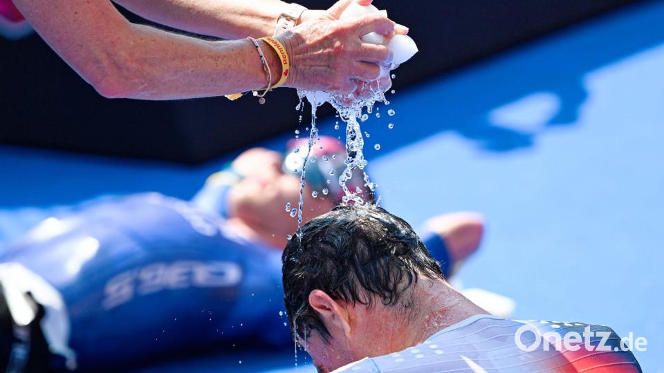Triathlon-EM: Iden wird im Ziel mit Wasser gekühlt Bild: Uwe Anspach/dpa
