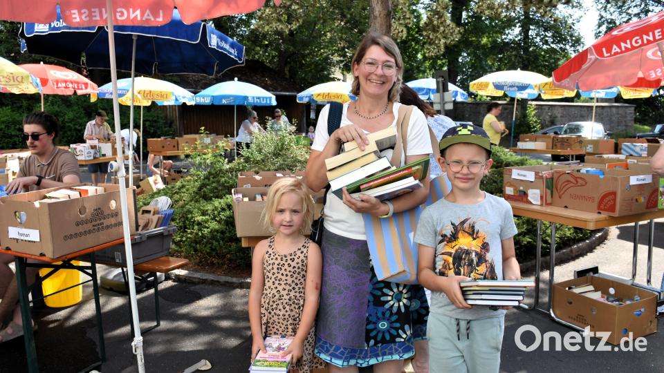 Die vierjährige Linda und der sechsjährige Magnus mit Mama Daniela Dörfler haben beim Bücherflohmarkt nicht geknausert und etwa 20 Bücher mitgenommen. Bild: Ulla Britta Baumer