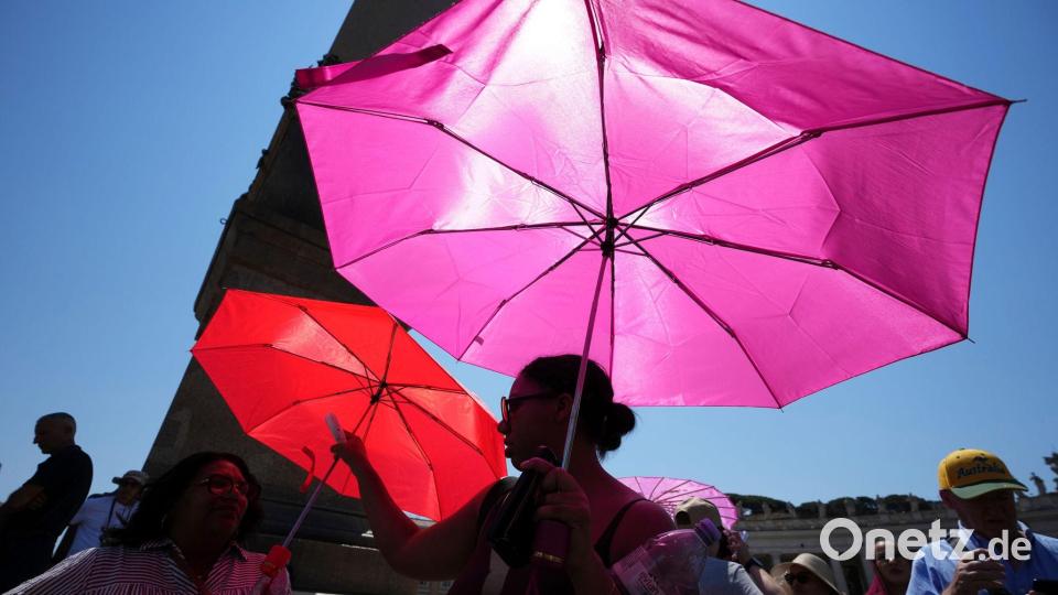 Gläubige warten mit Sonnenschirmen auf das Angelusgebet mit Papst Leo XIV. Bild: Alessandra Tarantino/AP/dpa