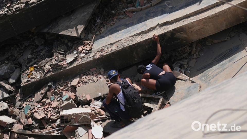 Eine Frau (r) sucht drei Tage nach den Erdbeben nach ihrem Bruder. Bild: Matias Delacroix/AP/dpa