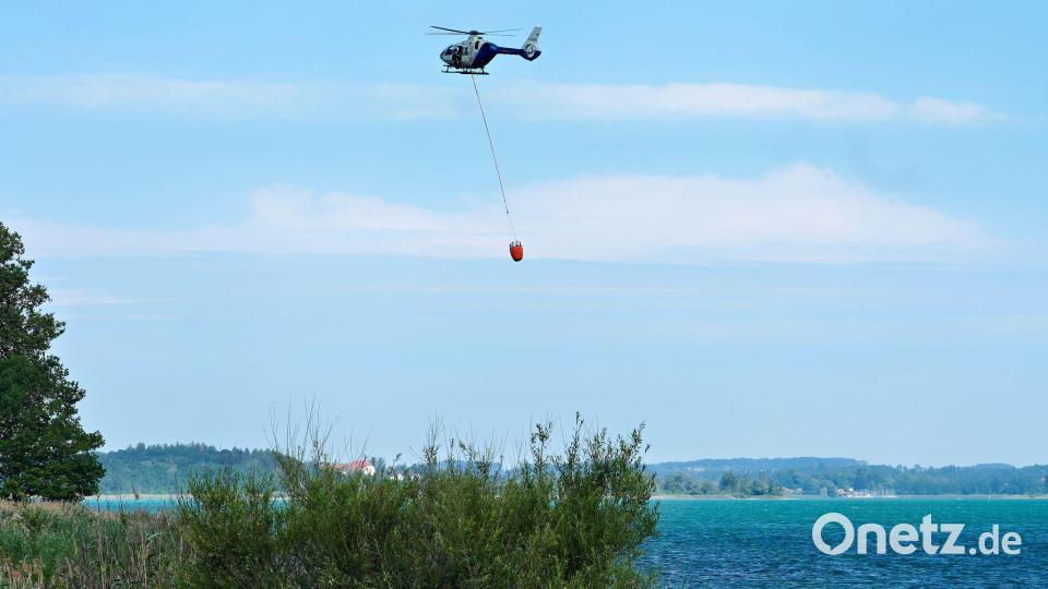 Ein Hubschrauber transportierte Löschwasser aus dem Chiemsee. Bild: Uwe Lein/dpa