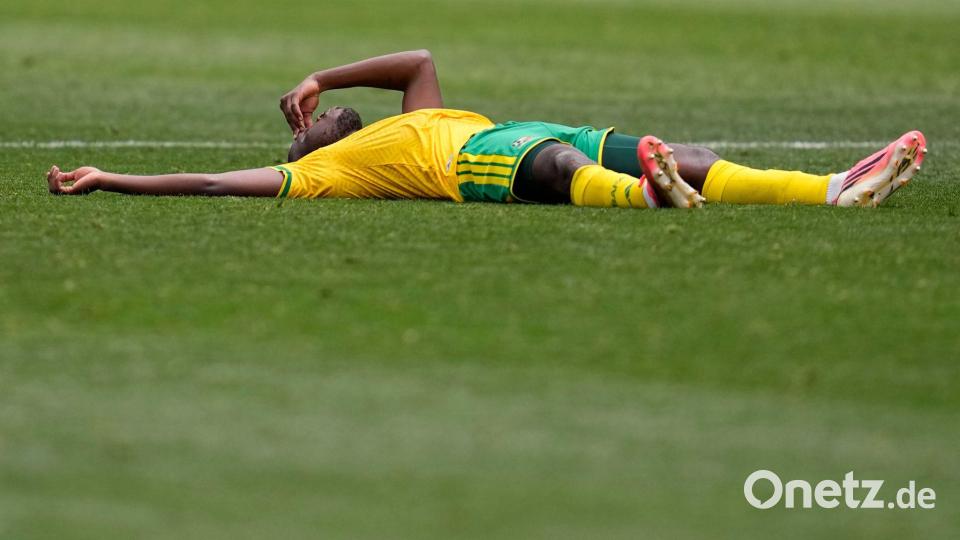 Der Südafrikaner Aubrey Modiba liegt nach dem Spiel auf dem Rasen Bild: Gregory Bull/AP/dpa