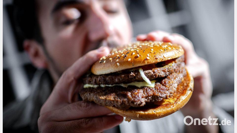 Illustration - Ein Mann beißt in einen Burger Bild: Sina Schuldt/dpa/dpa-tmn
