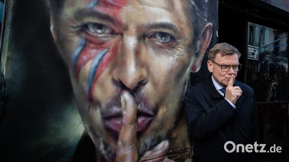 Der deutsche Außenminister Johann Wadephul (CDU) steht bei einem Rundgang durch das Stadtzentrum von Buenos Aires neben einem Graffiti von David Bowie. Bild: Boris Roessler/dpa