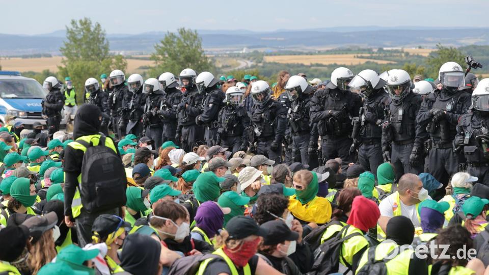 Eine Sitzblockade auf der Autobahn 71 - Polizisten umringen die Demonstranten. Bild: Michael Reichel/dpa