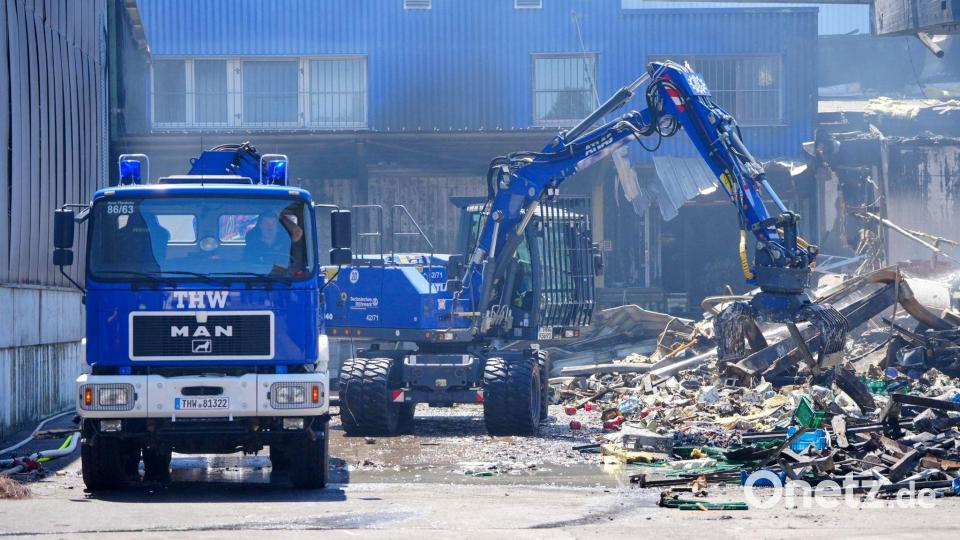 Einsatzkräfte des Technischen Hilfswerks (THW) beseitigen mit einem Bagger Schutt nach dem Feuer in einem Gewerbegebiet in Stuttgart. Bild: Enrique Kaczor/dpa