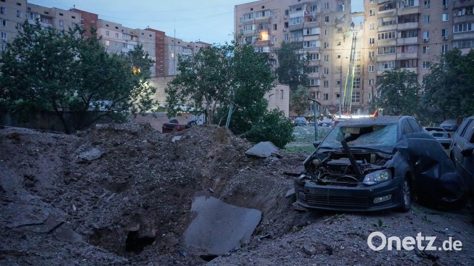 Ein Explosionskrater und beschädigte Autos sind neben einem Wohnhaus zu sehen. Bild: Efrem Lukatsky/AP/dpa