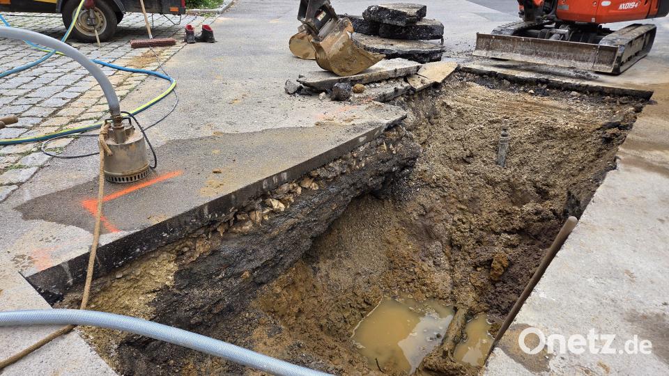 Der Bereich links neben der Pfütze wurde durch austretendes Wasser unterspült – hier muss der Asphalt ebenfalls noch aufgemacht werden. Die dicke, schwarze Schicht unter dem Asphalt ist Schlacke. Bild: Tobias Gräf