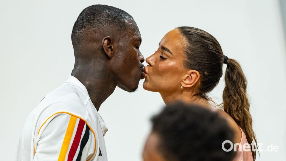 Basketball-Kapitän Dennis Schröder küsst seine Frau Ellen. Bild: Daniel Löb/dpa