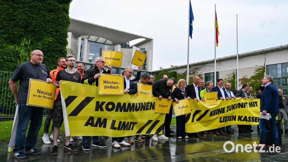 Vertreter mehrerer Städte und Kommunen demonstrieren mit Schildern und Bannern für finanzielle Unterstützung in Berlin. Bild: Jens Kalaene/dpa