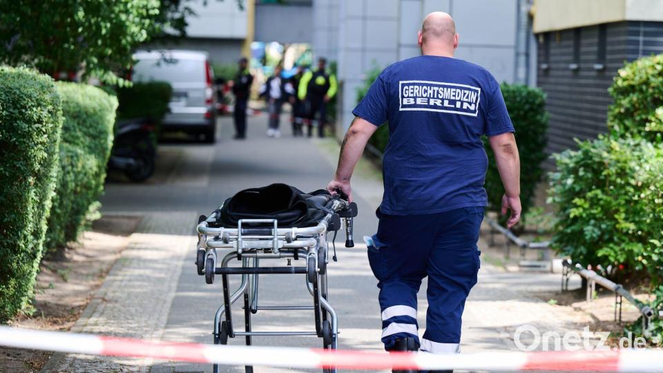 Ein Mann von der Gerichtsmedizin schiebt eine Bahre in der Nähe des Fundortes des toten Neugeborenen. Bild: Annette Riedl/dpa