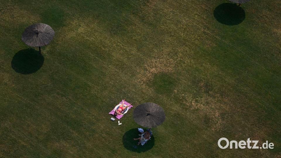 Eine Frau sonnt sich an einem Sommertag mit hohen Temperaturen in Pamplona. Bild: MIguel Oses/AP/dpa