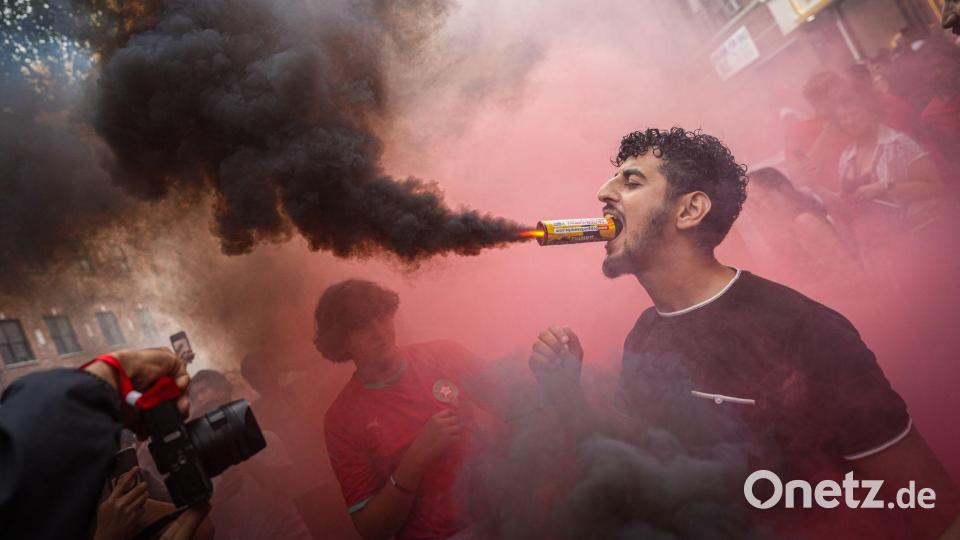 Ein marokkanischer Fan hält im New Yorker Stadtteil Queens eine Leuchtfackel mit dem Mund, nachdem die Mannschaft das Viertelfinalspiel der Fußball-Weltmeisterschaft gegen Frankreich verloren hat. Bild: Ryan Murphy/AP/dpa