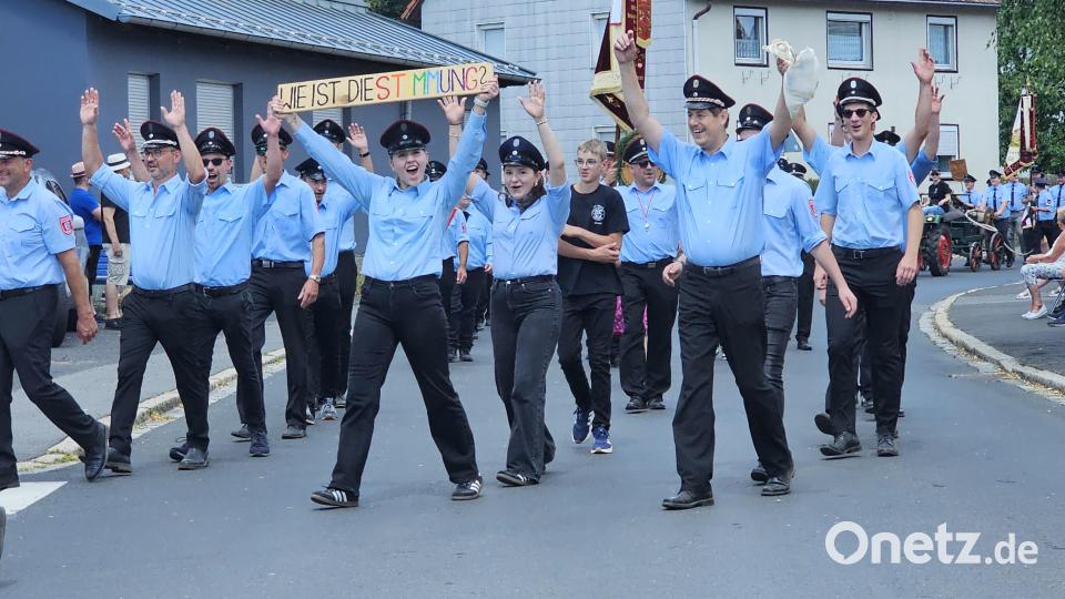 Beste Laune bewies der Patenverein, die Feuerwehr Wurz: Mit dem Schild „Wie ist die Stimmung?“ animierten die Kameradinnen und Kameraden die zahlreichen Zuschauer entlang der Festzugstrecke. Bild: Verena Schieder